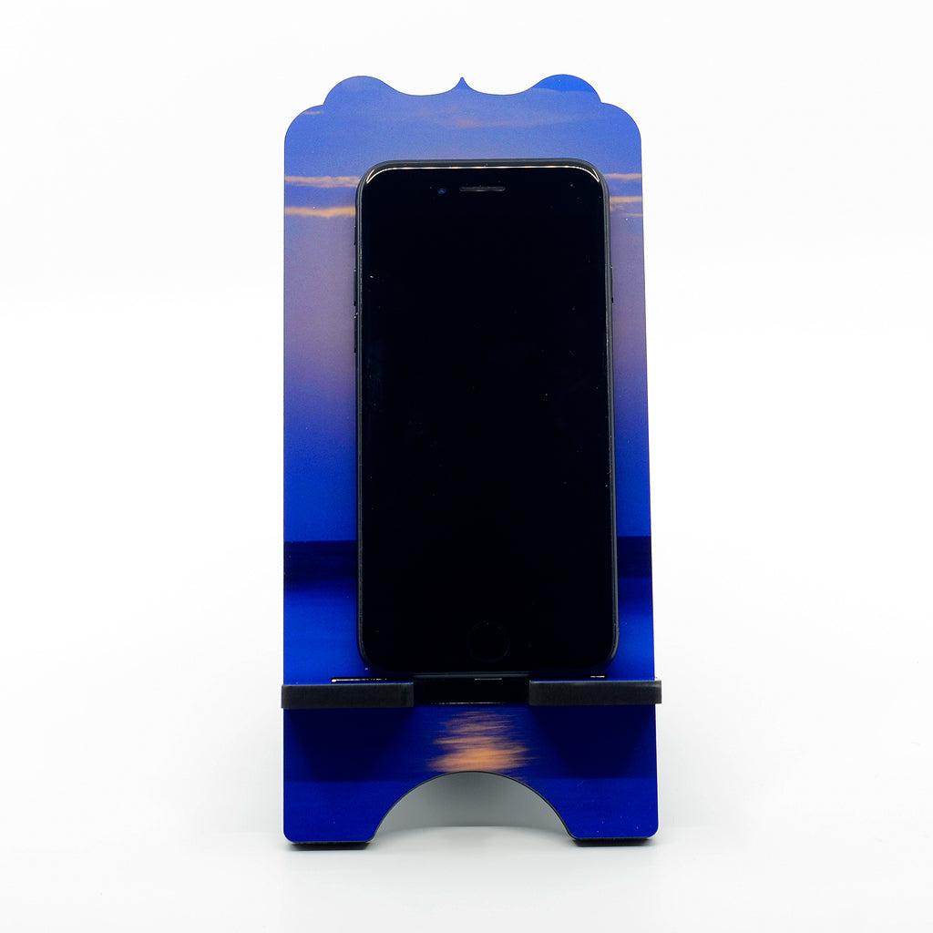 A photograph of a super moon over the ocean on a large phone stand with benelux top
