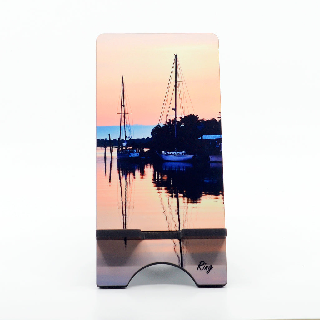 Sailboats in a marina photograph on a phone stand