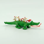 Ornament with gator wearing santa hat and shorebirds on top of it