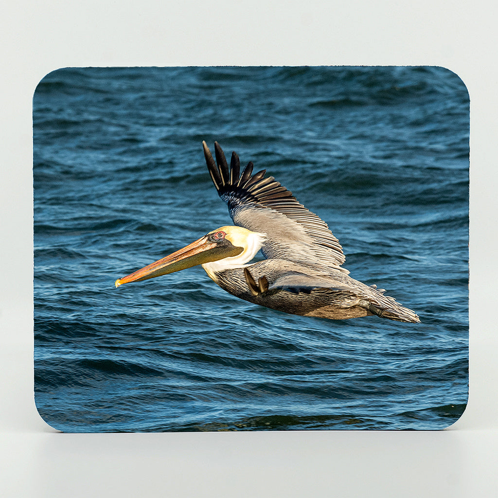 A flying pelican over the ocean photograph on a rectangle rubber mouse pad