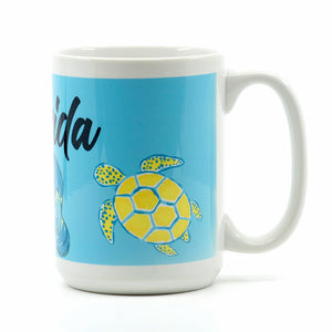 15 ounce white ceramic coffee mug wrapped with sea turtle, manatee and flamingo with words of Florida