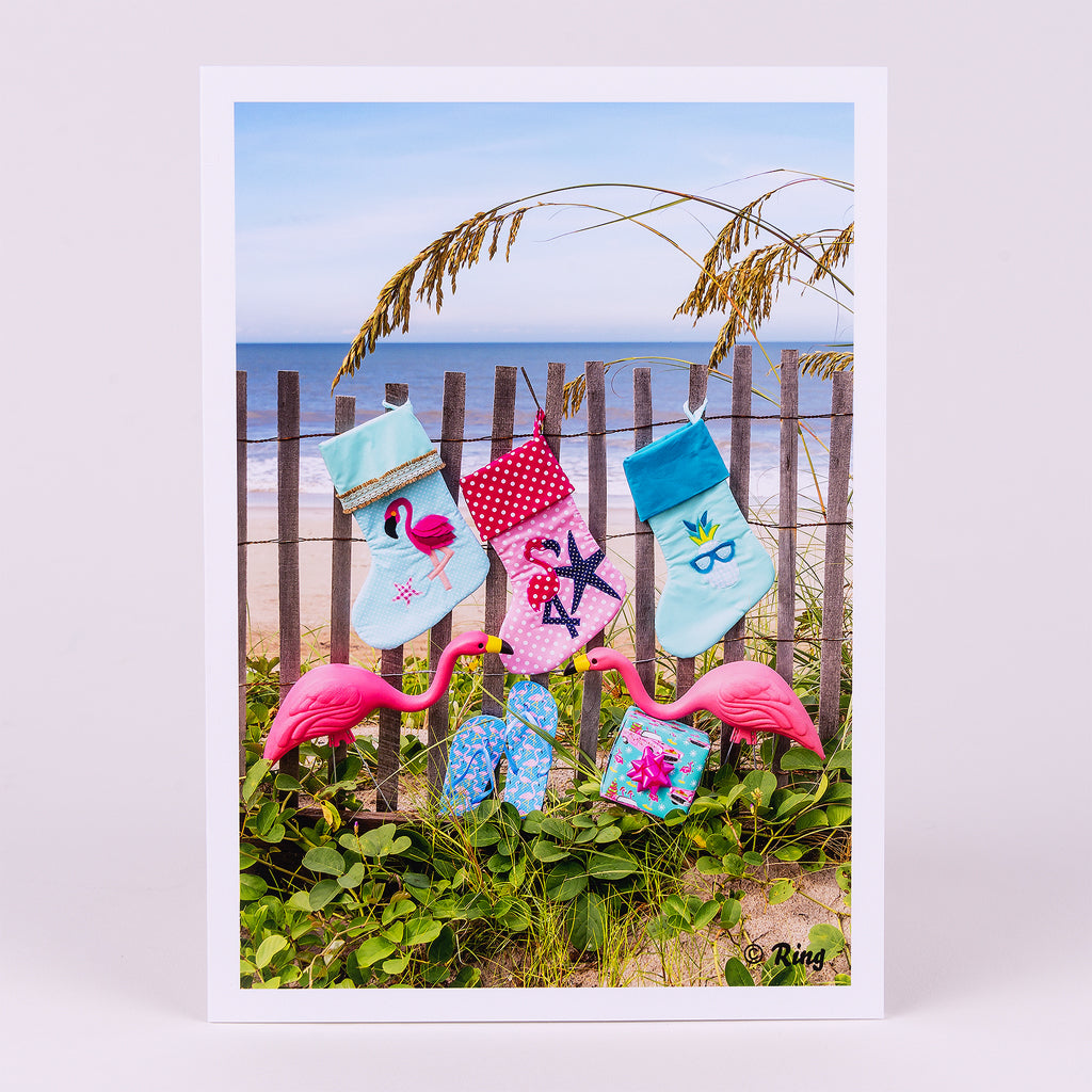 Christmas Notecard with 3 Stockings and Yard Flamingos on Dunes Fence on Beach